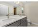 Bathroom featuring double sink vanity, quartz counters, grey cabinets, and a tiled shower at 4754 Caputo Ave, North Port, FL 34288