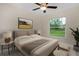 Bright bedroom featuring a ceiling fan and large window with views of the backyard at 4754 Caputo Ave, North Port, FL 34288