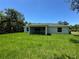 The home's exterior is framed by a vast backyard under a clear sky at 4754 Caputo Ave, North Port, FL 34288