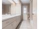 Bright bathroom features tile floors, a long vanity with storage, and access to the shower and back door at 4788 Abadan St, North Port, FL 34287