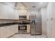 Kitchen featuring stainless steel appliances, custom cabinets, and tile floors at 4788 Abadan St, North Port, FL 34287