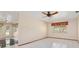Tile floored bedroom with ceiling fan, window, and view into adjacent room at 485 Dorchester St, Port Charlotte, FL 33954
