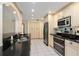Well-lit kitchen with stainless steel appliances, black countertops, and ample cabinet space at 485 Dorchester St, Port Charlotte, FL 33954