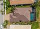 Overhead view of a home with a tiled roof, screened pool, and paver driveway at 5461 White Ibis Dr, North Port, FL 34287
