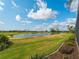 Scenic backyard view with a pond and well-manicured green golf course under a blue sky at 5461 White Ibis Dr, North Port, FL 34287