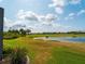 Beautiful backyard view overlooking a pond and green golf course on a sunny day at 5461 White Ibis Dr, North Port, FL 34287