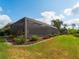 Backyard with manicured landscaping and a view of the screened-in lanai and pool area at 5461 White Ibis Dr, North Port, FL 34287