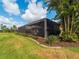 Expansive backyard with a screened-in patio, lush landscaping, and well-maintained lawn at 5461 White Ibis Dr, North Port, FL 34287