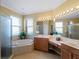 Primary bathroom with dual sinks, a soaking tub, and walk-in shower at 5461 White Ibis Dr, North Port, FL 34287
