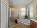 Primary bathroom features a soaking tub, walk-in shower, and natural light at 5461 White Ibis Dr, North Port, FL 34287