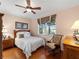 Cozy bedroom featuring a ceiling fan, a window with a view, and hardwood floors at 5461 White Ibis Dr, North Port, FL 34287