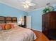 Airy bedroom with a ceiling fan, bright blue walls, and wood flooring at 5461 White Ibis Dr, North Port, FL 34287
