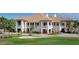 Close up of the community clubhouse with a golf sand trap, and golf carts outside at 5461 White Ibis Dr, North Port, FL 34287