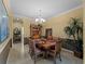 Formal dining room with classic chandelier and elegant decor creates a warm, inviting atmosphere at 5461 White Ibis Dr, North Port, FL 34287