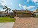 Beautifully landscaped home featuring a paver driveway and three-car garage at 5461 White Ibis Dr, North Port, FL 34287