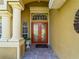 Elegant home entrance with double doors, decorative columns, and manicured landscaping at 5461 White Ibis Dr, North Port, FL 34287
