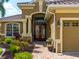 Elegant entryway with double doors, decorative columns, and lush landscaping at 5461 White Ibis Dr, North Port, FL 34287