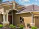 Attractive home entrance with decorative columns, a tiled roof, and manicured landscaping at 5461 White Ibis Dr, North Port, FL 34287