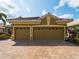 Exterior shot showcasing the home's three-car garage with a paved driveway at 5461 White Ibis Dr, North Port, FL 34287