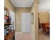 Hallway view with tiled flooring, a white door, and a glimpse into the dining room at 5461 White Ibis Dr, North Port, FL 34287