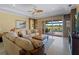 Cozy living room with sliding glass doors leading to a private lanai and pool area at 5461 White Ibis Dr, North Port, FL 34287
