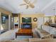 Bright living room with tile floors, decorative ceiling fan, and large TV at 5461 White Ibis Dr, North Port, FL 34287