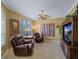 Comfortable living room featuring two leather recliners, a ceiling fan, and ample natural light at 5461 White Ibis Dr, North Port, FL 34287
