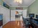 Well-lit home office with hardwood floors, fresh paint, and views of the kitchen at 5461 White Ibis Dr, North Port, FL 34287