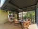Comfortable screened-in patio featuring an outdoor seating area with a fire pit and ceiling fans at 5461 White Ibis Dr, North Port, FL 34287