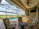 Screened-in pool and patio with chairs, a table, and views of the lake and golf course at 5461 White Ibis Dr, North Port, FL 34287