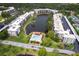 Scenic aerial view of condo community with a pool, lake and mature landscaping at 6070 80Th N St # 215, St Petersburg, FL 33709