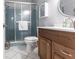 Bathroom featuring a shower with glass doors, white tile floors, and a wooden vanity at 6070 80Th N St # 215, St Petersburg, FL 33709