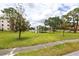 Expansive green space with mature trees and scenic pond in the background at 6070 80Th N St # 215, St Petersburg, FL 33709