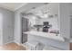 Modern kitchen showcasing stainless steel appliances, white cabinetry, and granite countertops with bar seating at 6070 80Th N St # 215, St Petersburg, FL 33709