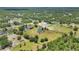 Beautiful home with a pond and outbuildings nestled among lush greenery, viewed from above at 6242 Tropicaire Blvd, North Port, FL 34291