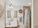 This bathroom offers ample vanity space with a granite countertop, a coastal-themed wreath, and a shower at 6242 Tropicaire Blvd, North Port, FL 34291