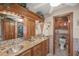 Elegant bathroom with double sinks, granite countertops, and separate toilet room at 6242 Tropicaire Blvd, North Port, FL 34291
