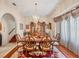 Formal dining room features hardwood floors, a large window with curtains, and a decorative chandelier at 6242 Tropicaire Blvd, North Port, FL 34291