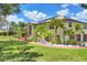 Beautiful home with a lush lawn, brick walkway, mature trees and a three-car garage at 6242 Tropicaire Blvd, North Port, FL 34291