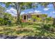 Charming home with solar panels, well-manicured lawn, walkway, and mature trees at 6242 Tropicaire Blvd, North Port, FL 34291
