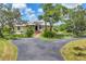 A home with solar panels, brick walkway, lush lawn and mature trees lining the driveway at 6242 Tropicaire Blvd, North Port, FL 34291