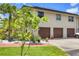 Three car garage with a brick walkway surrounded by lush landscaping at 6242 Tropicaire Blvd, North Port, FL 34291
