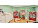 Well-lit laundry room with red washer and dryer sets and ample storage space at 6242 Tropicaire Blvd, North Port, FL 34291