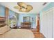 A well-lit primary bedroom boasts a wooden dresser, striking ceiling fan and a large arched window at 6242 Tropicaire Blvd, North Port, FL 34291