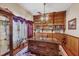 A home office with a large wooden desk, built-in bookshelves, and a decorative ceiling fan at 6242 Tropicaire Blvd, North Port, FL 34291