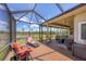 Spacious screened patio with lounge chairs, a view of the lake, and outdoor lighting at 6242 Tropicaire Blvd, North Port, FL 34291