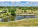 Pond with surrounding greenery and palm trees offers a peaceful view at 6242 Tropicaire Blvd, North Port, FL 34291