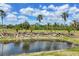 Scenic pond with rock features and palm trees, creating a tranquil outdoor space at 6242 Tropicaire Blvd, North Port, FL 34291
