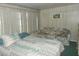 Comfortable bedroom features a double bed with patterned bedding, a floral loveseat, and a window with vertical blinds at 6832 Holo Ct, North Port, FL 34287