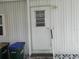 The mobile home entrance is secured with a sturdy white door featuring a window with a security view at 6832 Holo Ct, North Port, FL 34287